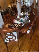 Full view of mahogany-finish dining table set with decorative items and chairs