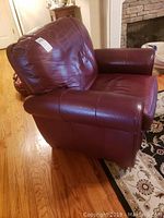 Side angle view of burgundy leather recliner showing profile and upholstery