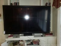 Front view of Sharp TV on stand, powered off