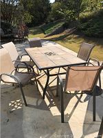 Full view of table and chairs set on patio with surrounding landscape visible