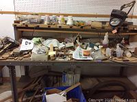 Work table with woodworking supplies, glue bottles, tools, and Dremel tool on tabletop.