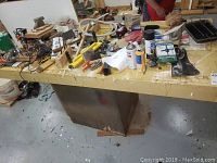 Full view of plywood-topped workbench with items spread across surface