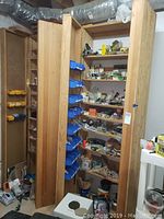 Overall view of two wooden cabinets loaded with hardware and tools