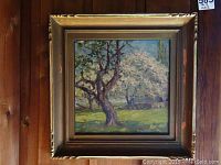 Frontal view of framed oil painting depicting blossoming trees