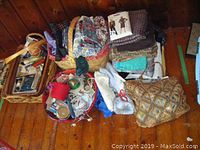 Overview photo of multiple fabric bundles, sewing notions, and baskets arranged on wood floor