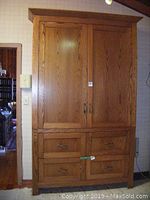 Full front view of oak cabinet showing two upper doors and four lower drawers