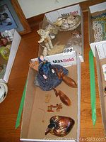 Overview of lot showing bone carving doll, seashells, wooden deer, wooden bird container, and assorted small items.