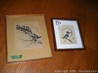 Two framed bird art prints shown together on a wooden floor.