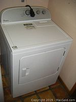 Full front photo of white Whirlpool electric dryer with door closed, showing overall appliance shape and control panel.