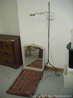 Full view of mirror, rug, and wrought iron lamp displayed together.