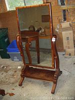 Front view of the old mahogany tiltable dressing mirror showing full frame and glass surface reflecting surrounding items.