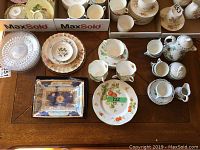 Photo of Royal Worcester Millennium dish, assorted china and glass plates, and tea sets on wooden table