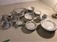 Complete display of the Johnson Bros Snowhite Regency dinnerware set, showing plates, bowls, cups, cream and sugar set, gravy bowl, serving bowls, and platter.