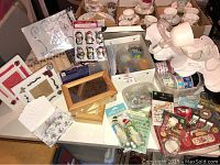 Overview of the crafting lot showing ribbons, mosaic kit, light fixture, wooden box, and assortment of embellishments and craft supplies. Cups and saucers are visible but not included per seller.