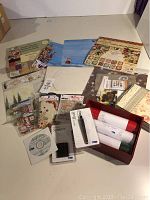 Scrapbooking supplies spread out showing paper pads, stamps, embellishments, tools, and embossing folder.