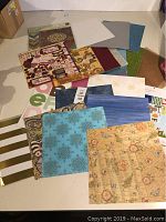 Collection of assorted scrapbooking papers displayed on a white surface
