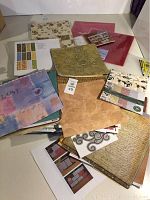 Stack of various scrapbooking papers with different patterns and textures on a white surface.