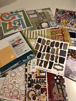 Overview of various scrapbooking kits and paper pad showing different themed papers, stickers, and die cuts.