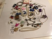 Overview photo showing the entire vintage jewelry lot with necklaces, earrings, bracelets, pins, and pendants.