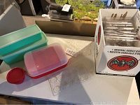 Overview of Tupperware containers and clear chocolate candy molds on white table
