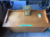 Top views of the wooden hope chest with gold clock placed on it, showing measurements on tape.