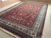 Full view of the large oriental area carpet laid out in a room showing the overall color scheme and size.