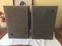Front view of pair of Infinity 2500 speakers with brown fabric covers and Infinity logos on each speaker grille.