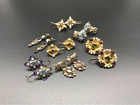 Seven pairs of earrings arranged on black background