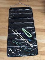 Full view of the five jewelry pieces inside the hanging jewelry organizer laid flat on the floor.