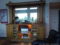 Wide view of wooden cabinet housing speakers and audio components