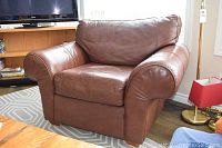 Overall front angle view of the armchair, capturing shape and leather color