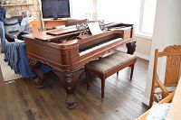 Full front view of piano and bench in room setting