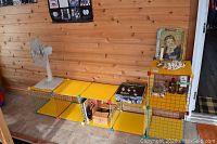 Yellow 6-cube wire bin shelving with collectible items on and around it including Coca-Cola tray and Beatles Trivial Pursuit game