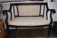 Full front view of settee showing wooden frame and striped upholstery