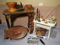 Full view showing two wooden step stools, the large carved fish tray, wooden bowls, small carved animal totem pole, brass bell, wooden butter mold, pottery ghost house, and other small items.