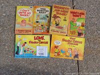 Seven Family Circus cartoon books laid out on a concrete surface showing front covers with colorful cartoon illustrations and titles.