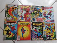 Seven Spider-Man comic books with colorful vintage covers showing various storylines and villains