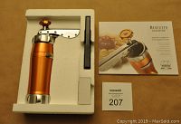 Cookie press in foam packaging with manual booklet next to it.