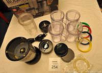 Full set laid out on table showing base unit, cups, blades, rings, and power cord