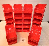 Photo showing 24 red plastic parts bins stacked in rows and columns.