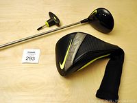 Nike Vapor driver golf club with shaft, headcover, and torque wrench on table.
