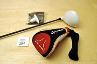 Full view of TaylorMade R11 left-handed driver with accessories and headcover on table.