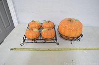 Set of ceramic pumpkin dishes and wire racks shown with measuring tape to show size
