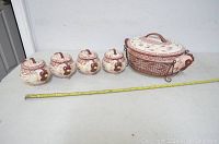 Full set of 5 dishes with lids and wire rack displayed with measuring tape for scale.