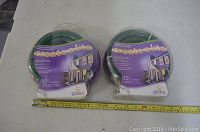 Two packaged 12 ft Globe Create-a-lite LED rope light rolls on table next to measuring tape, showing packaging and length.