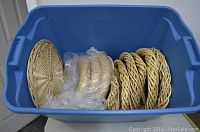 Blue plastic tote filled with multiple new rattan wreaths and heart-shaped rattan decorations, some wrapped in plastic.