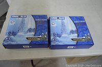 Photo showing two unopened boxes of Emerald outdoor net lights on a white table.