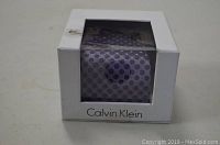 Calvin Klein tie visible through plastic window of white box with box damage on the top corner