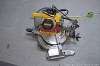 Overhead view of Dewalt miter saw showing base, table, blade guard, handle and power cord.