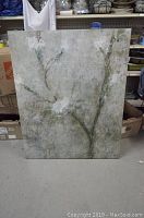 Full view of large textured botanical print artwork against storage area background